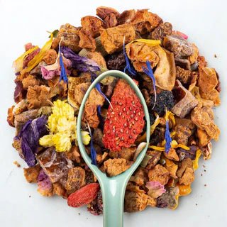 Morceaux de pommes, baies de goji, écorces d'agrumes et pétales de fleurs pour infusion fruitée.